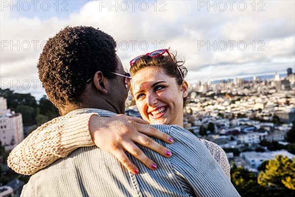 Couple hugging near scenic view of cityscape