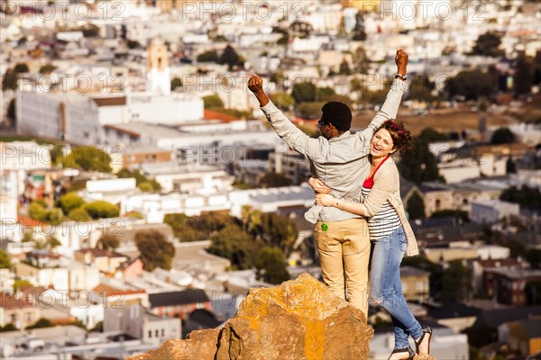 Couple cheering near scenic view of cityscape