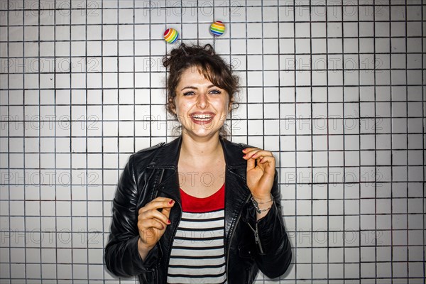 Caucasian woman wearing colorful antenna near wall