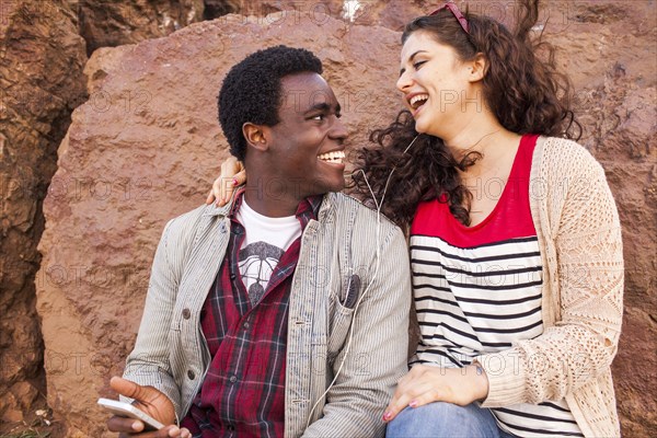 Smiling couple listening to earbuds together