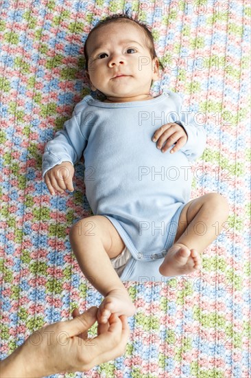 Mother tickling foot of baby boy