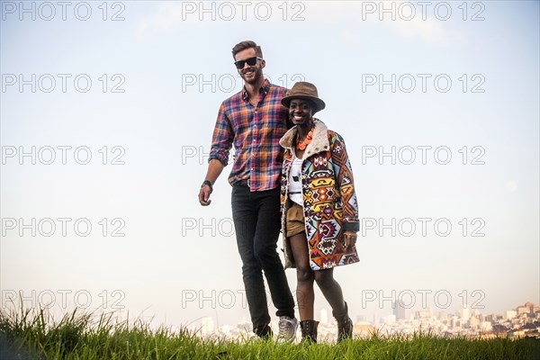 Couple walking together in grassy field