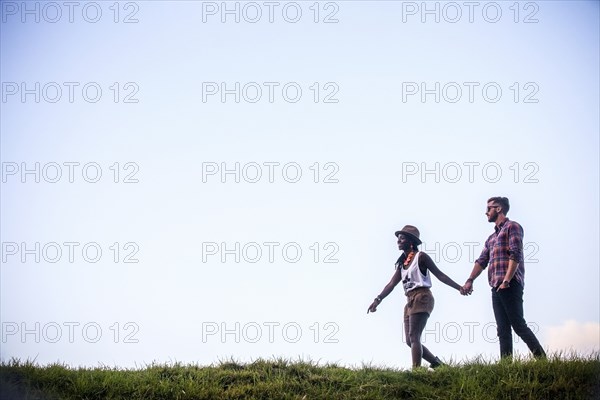 Couple walking together in grassy field