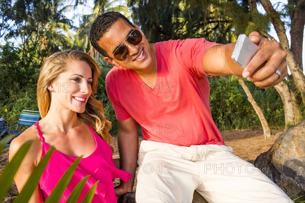 Couple taking cell phone photograph outdoors