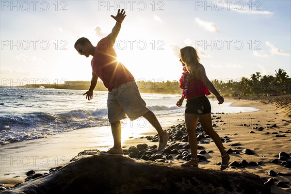 Couple playing on rocks on beach