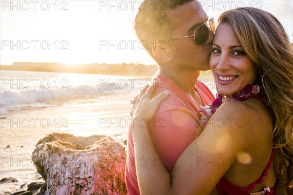 Man kissing girlfriend on beach