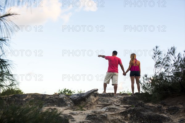 Low angle view of couple enjoying scenic view at beach