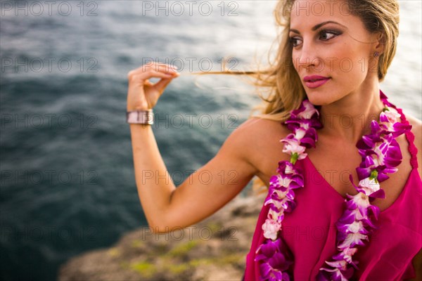 Caucasian woman relaxing on rocks at beach