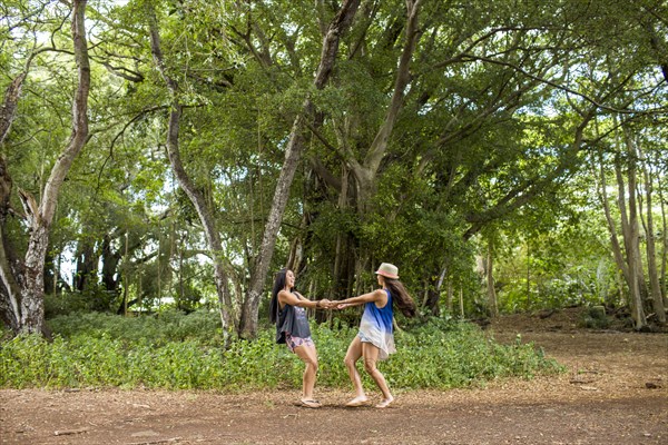 Pacific Islander women playing in forest