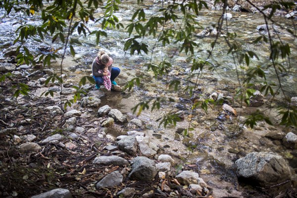 High angle view of Caucasian mother and baby at rocky river