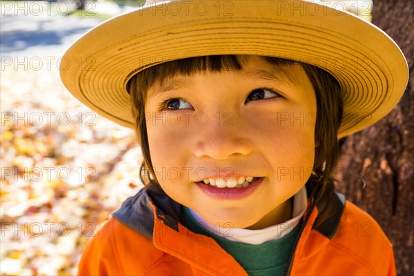 Close up of smiling mixed race boy wearing sun hat