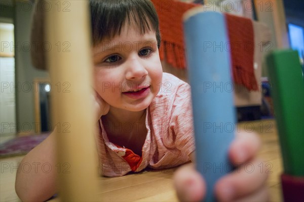 Caucasian boy playing with blocks on floor