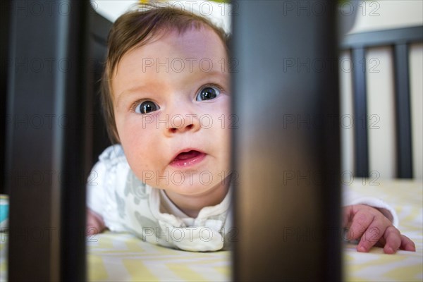 Close up of Caucasian baby girl laying in crib