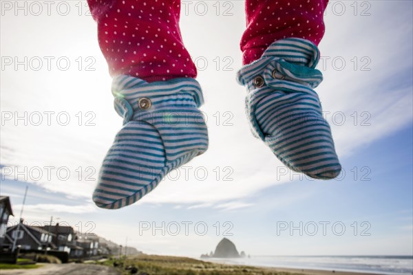 Close up of feet of Caucasian baby hovering over beach