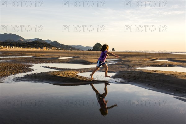 Caucasian girl running in tide pools on beach