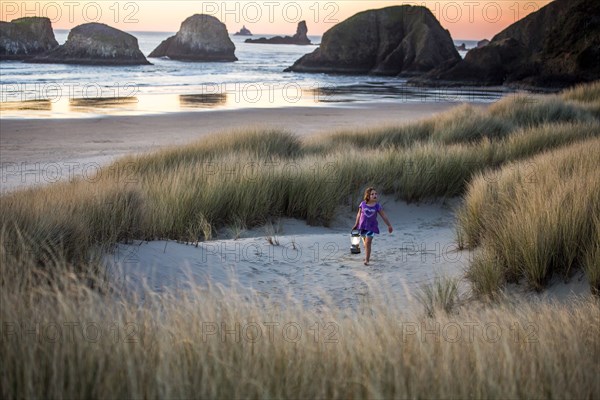 Caucasian girl carrying lantern on beach