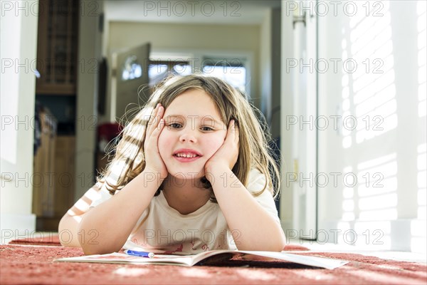 Close up of Caucasian girl reading book on floor