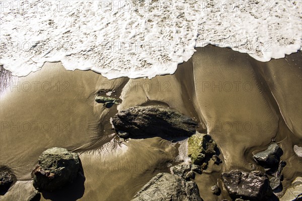 Ocean waves washing up on rocky beach