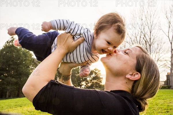 Caucasian mother kissing baby girl outdoors