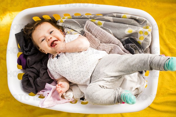 Caucasian baby girl laying in laundry basket