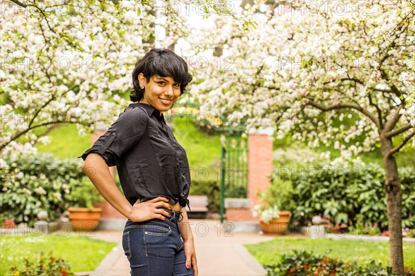 Hispanic woman smiling under flowering trees