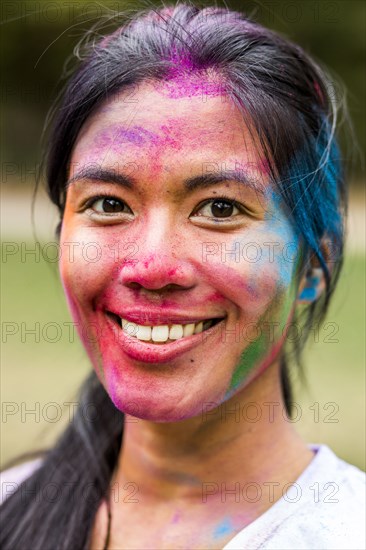 Smiling Asian woman covered in pigment powder