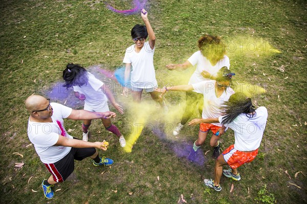 Friends throwing pigment powder in playful fight