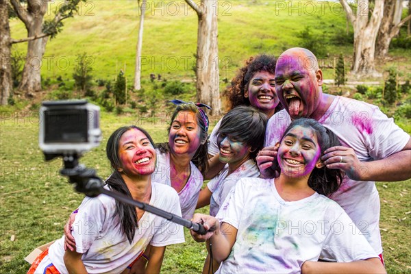 Friends covered in pigment powder using selfie stick