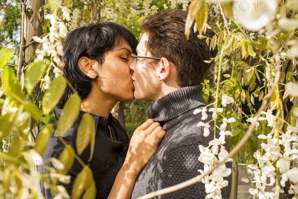 Close up of couple kissing in foliage