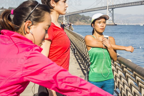 Runners stretching on urban bridge