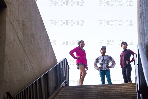 Runners standing at top of urban staircase