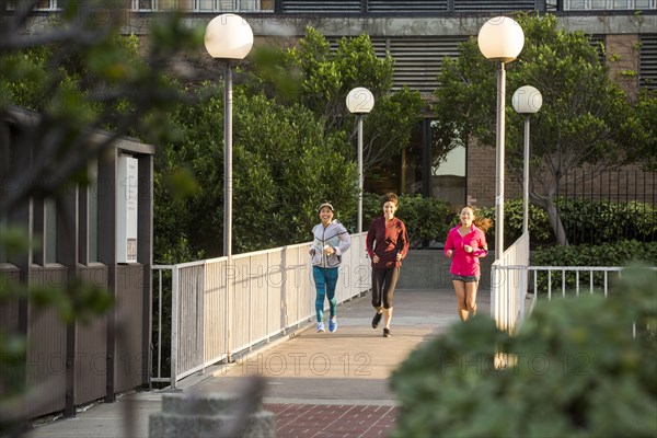 Women running on urban footbridge