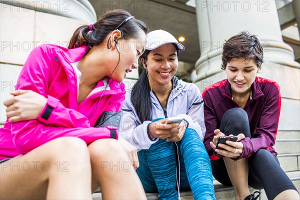 Low angle view of runners using cell phones on staircase