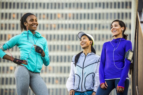 Runners laughing near highrise building