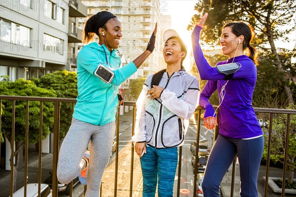 Runners high-fiving in city