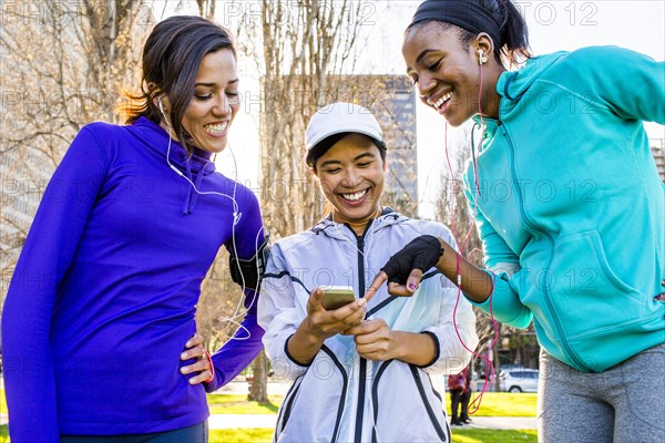 Runners using cell phone in urban park