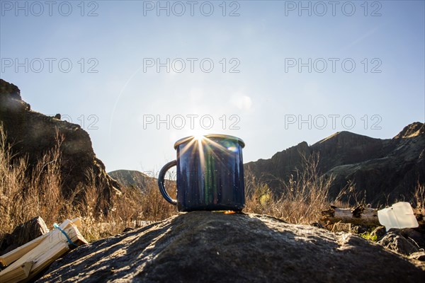 Close up of camping mug under remote mountains