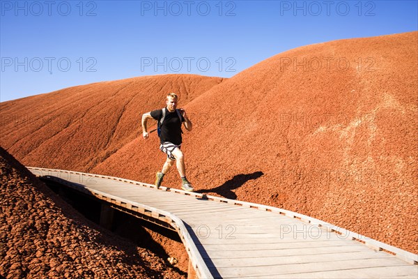 Caucasian man running on walkway in desert hills