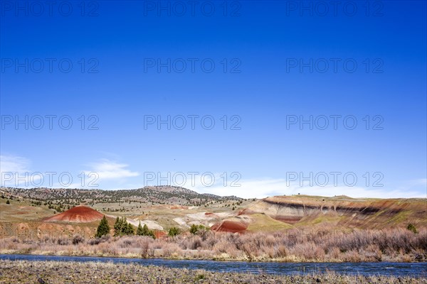 Creek near hills in desert landscape under blue sky