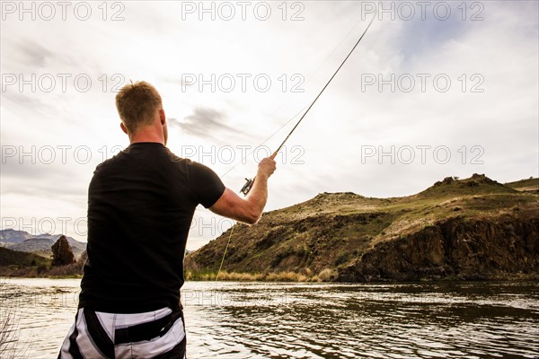 Caucasian man fishing in remote lake