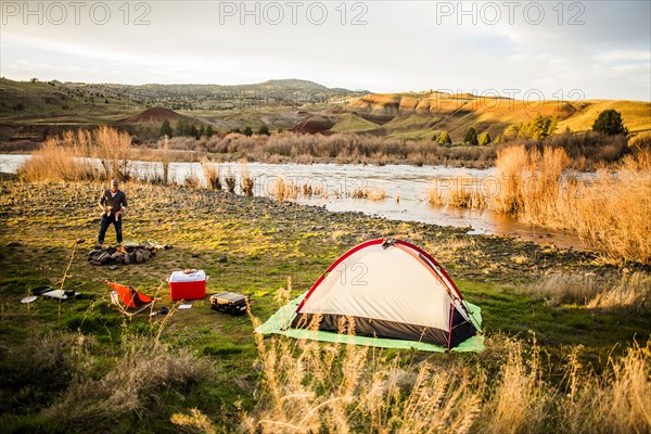 Caucasian man camping near remote river