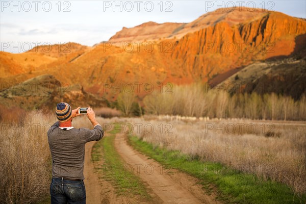 Caucasian man photographing desert hills