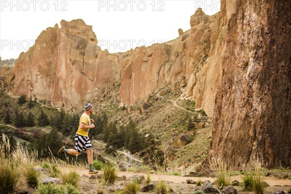 Caucasian man running near desert hills