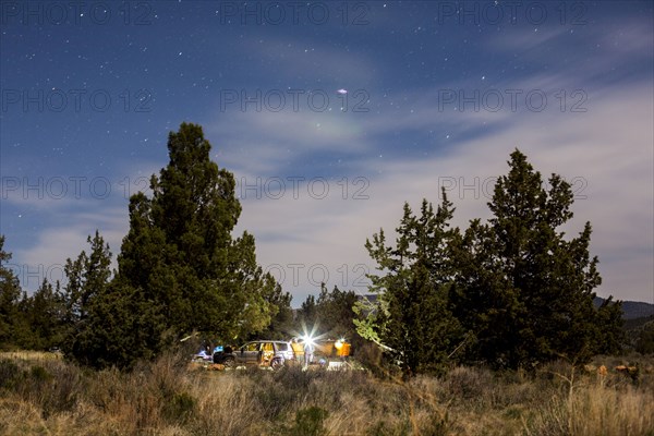 Campsite in remote field under cloudy sky