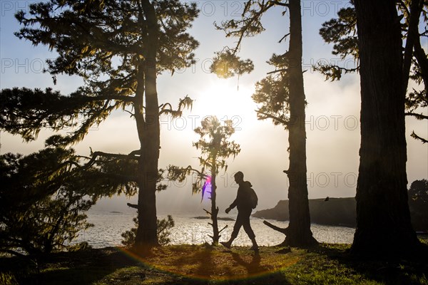 Caucasian hiker walking near ocean