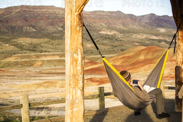 Caucasian man drinking coffee in hammock