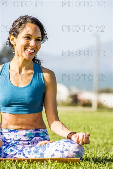 Hispanic woman practicing yoga in urban park
