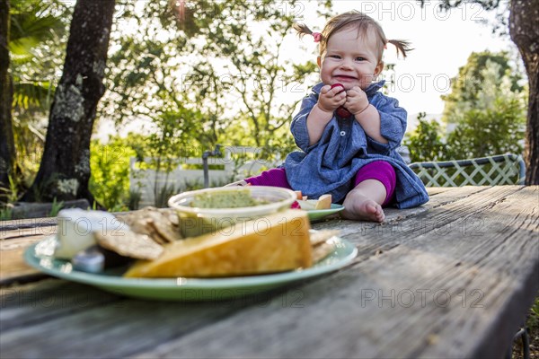 Caucasian baby girl sitting on patio table