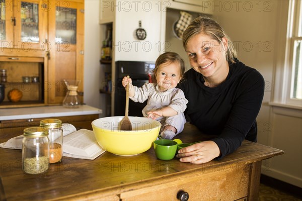 Caucasian mother and baby girl baking in kitchen