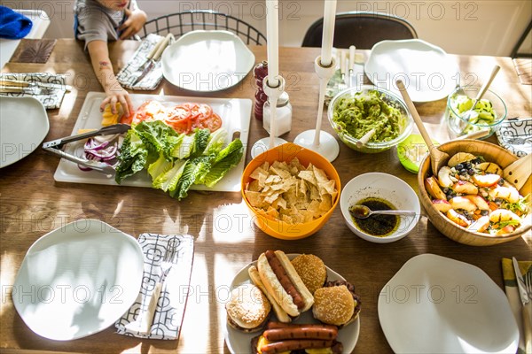 Baby girl reaching for vegetables at buffet table